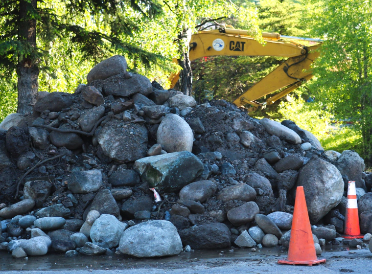 excavator in the back of rocks